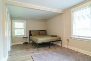 a bedroom with a bed in a room with two windows at The Blue Garden Escape in Saint Charles