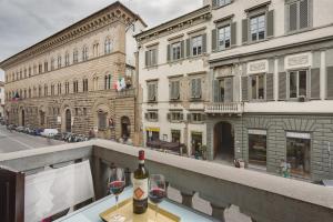 Una mesa con dos copas de vino en un balcón. en B&B Cavour10 Firenze, en Florencia