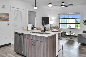 a kitchen with a sink and a living room at The Well #203 in Zephyrhills