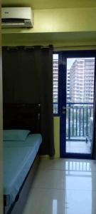 a bedroom with a bed and a window with a view at Ladybugs Condotel SR in Manila