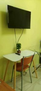 a table and a chair with a plant on top of it at Ladybugs Condotel SR in Manila