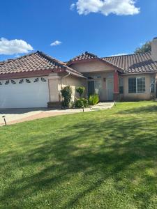 a house with a garage and a grass yard at Master bedroom in Bakersfield