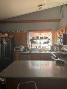 a kitchen with a refrigerator and a counter top at Master bedroom in Bakersfield