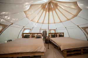 two beds in a room with a tent at Glamping Riverside Skadar lake in Železnička Stanica Zeta
