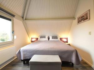 a bedroom with a bed with two lamps and a window at De Zeediek in Herkingen