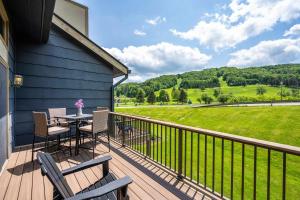 a balcony with a table and chairs and a view of a field at Walk to Lift Across from Holiday Valley AC in Ellicottville
