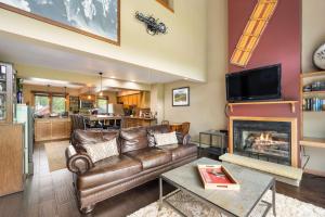 a living room with a leather couch and a fireplace at Walk to Lift Across from Holiday Valley AC in Ellicottville