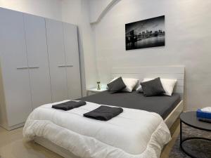 - une chambre avec un lit doté d'oreillers blancs et noirs dans l'établissement Brand new - Stylish Studio Near to Yas & Airport, à Abu Dhabi