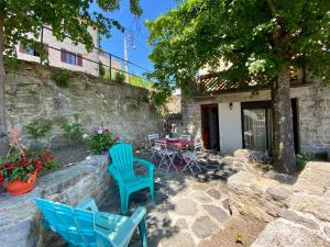 ブラヴォジーにあるCharmante maisonnette à Blavozy, proche du Puy-en-Velay, avec terrasse privative, WiFi, et parking - FR-1-582-57の石造りの建物の前に座る青い椅子2脚