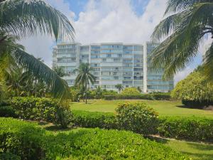 a large building with palm trees in front of it at Beachfront apartments Cancun in Cancún
