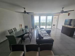 a living room with a table and chairs and a television at Beachfront apartments Cancun in Cancún