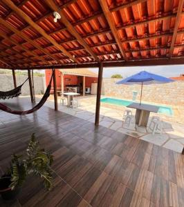 a patio with a hammock and a table and an umbrella at Chacara Linhares in Pirenópolis