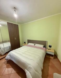 a large white bed in a room with green walls at Casa Vacanze Sole in Monte Petrosu