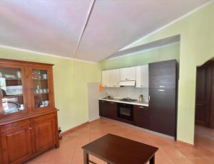 a kitchen with a black refrigerator and a table at Casa Vacanze Sole in Monte Petrosu