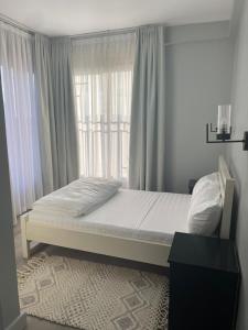 a bed in a bedroom with a large window at 3 bedroom 3bathroom apartment at Kingfisher Naalya Estates Kampala, Uganda in Kampala