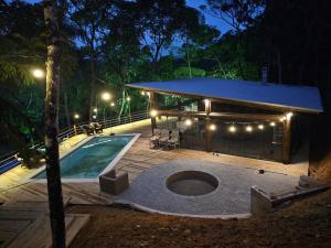 a house with a swimming pool at night at Cabana em Aguas Mornas in Santo Amaro da Imperatriz