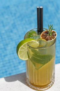 a drink in a glass with a slice of lime at All'oro in Njivice