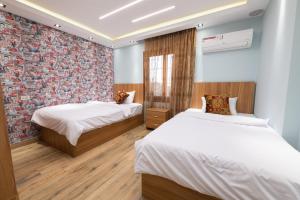 a bedroom with two beds and a brick wall at Royal Heliopolis in Cairo