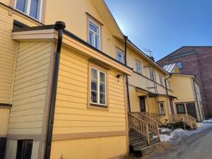 a yellow house with a wooden at Historic SELF-SERVICE apartment in downtown Vaasa in Vaasa +2 photos