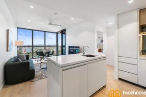 a kitchen with a counter and a living room at Elevated Luxury at QWR City & River Views in Brisbane