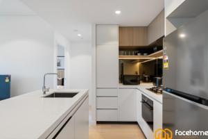 a white kitchen with a sink and a refrigerator at Elevated Luxury at QWR City & River Views in Brisbane