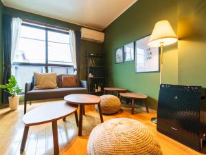 宇多津町utasto olive 1F的客厅里有一张沙发、一张桌子和几把椅子。