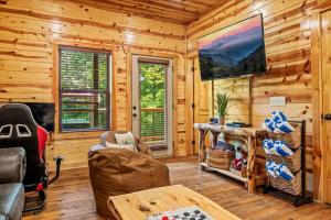 ein Blockhaus-Wohnzimmer mit Kamin und Fernseher in der Unterkunft Pinot Splash in Gatlinburg