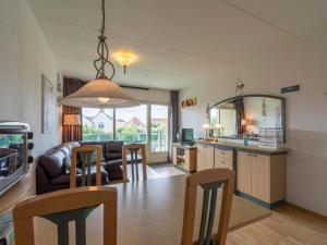 cocina y sala de estar con sofá y sillas en Apartment in Callantsoog near the dunes, en Callantsoog