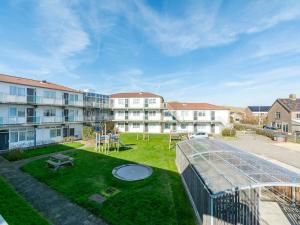 un complejo de apartamentos con un patio con jardín en Apartment in Callantsoog near the dunes, en Callantsoog