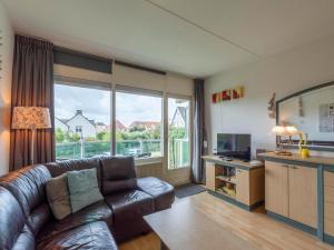 Una sala de estar con un sofá y una ventana grande. en Apartment in Callantsoog near the dunes, en Callantsoog