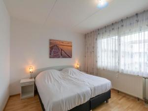 Un dormitorio blanco con una cama y una ventana. en Apartment in Callantsoog near the dunes, en Callantsoog