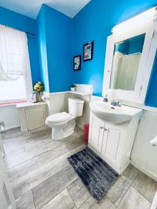 a blue bathroom with a toilet and a sink at Prime and Precious location The Red House Room3 in Charlottetown +10 photos