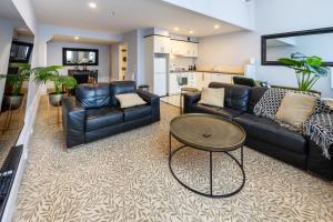 a living room with couches and a table at 2BR Apartment, OGB, Central, Pool and Parking in Christchurch