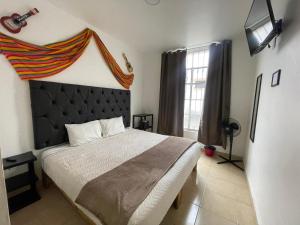 Un dormitorio con una cama grande con cabecero negro. en Aldama, en Morelia
