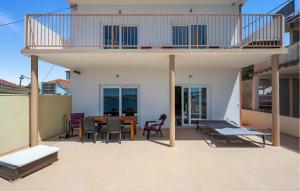 a house with a balcony with a table and chairs at 2 Bedroom Nice Apartment In Brodarica in Brodarica