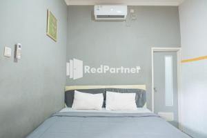 Postel nebo postele na pokoji v ubytování Crown Residence Hotel near Tugu Yogyakarta Mitra RedDoorz