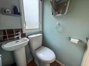 a bathroom with a white toilet and a sink at Great 6 Berth Spacious Caravan With Large Outdoor Space Ref 50056L in Great Yarmouth +17 photos