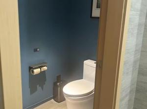 a bathroom with a white toilet in a blue wall at Atour Hotel Chengdu Jinli Hongpailou Subway Station in Chengdu +40 photos