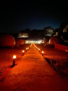 a row of candles on a road at night at Moon Camp in Al Jafr