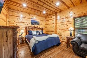 ein Schlafzimmer mit einem Bett in einer Blockhütte in der Unterkunft Pinot Splash in Gatlinburg + 47 Fotos