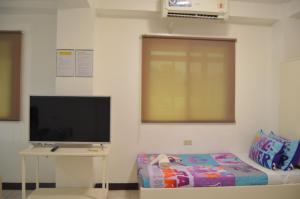 a room with a tv and a table and a bed at Good Shepherd Apartelle in Urdaneta