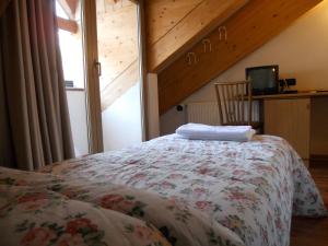 a bedroom with a bed with a floral bedspread at Hotel Orsa Maggiore in Falcade
