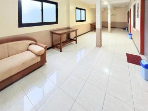 a living room with a couch and a table at RedDoorz Syariah at Nusa Indah near BNS in Batu