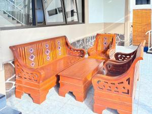 two wooden benches and a wooden table and chairs at RedDoorz Syariah at Nusa Indah near BNS in Batu