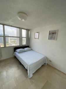 a bedroom with a bed in a room with windows at Downtown Isla Verde Beachfront Apartment with Pool and Parking in San Juan +7 photos