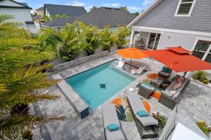 an overhead view of a swimming pool with an orange umbrella at Tipsy Turtle l Heated Pool l Walk to Beach in Saint Augustine
