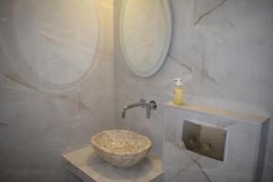 ein Badezimmer mit Aufsatzwaschbecken und Spiegel in der Unterkunft Fotini's Studios 1 in Toroni