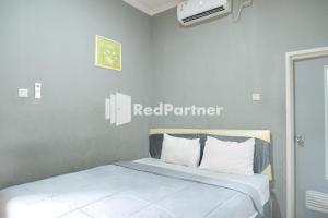Postel nebo postele na pokoji v ubytování Crown Residence Hotel near Tugu Yogyakarta Mitra RedDoorz