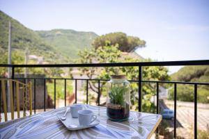 a table with a glass jar with a plant in it on a balcony at Tenuta Coppola casa vacanze in Gragnano