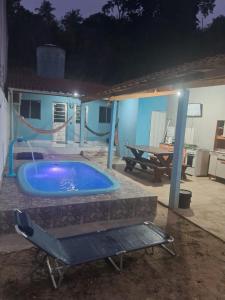 a hot tub in a yard with a table at Casa temporada Barra de Jequia-Al in Jequia da Praia